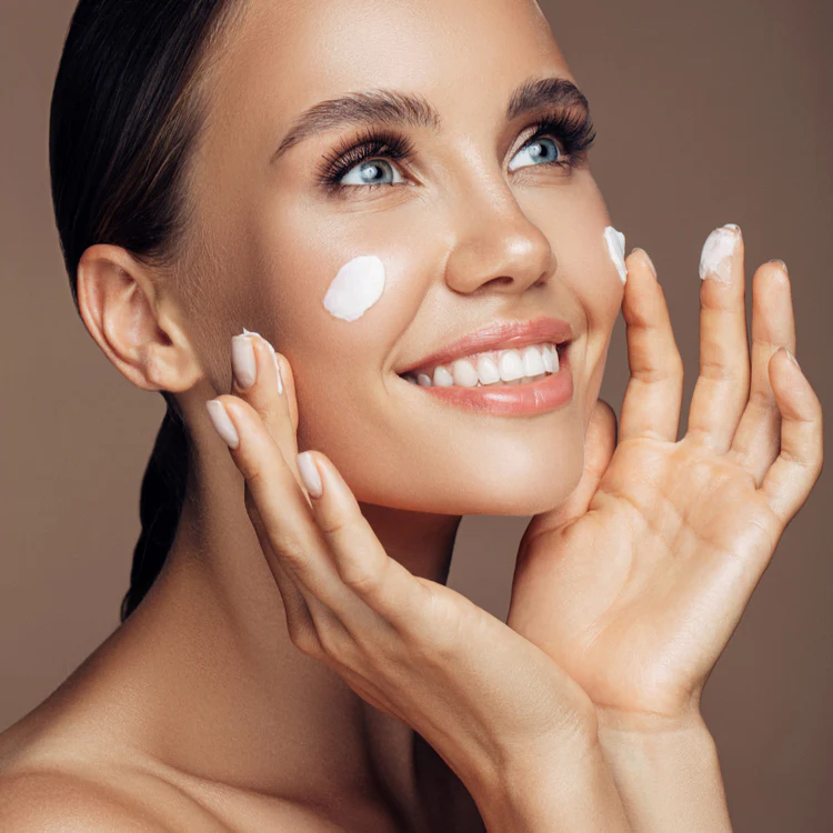 Donna con pelle luminosa che applica la crema Eudalie